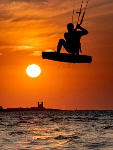 Minnis Bay sunset over Reculver Towers with jumping kitesurfer 10