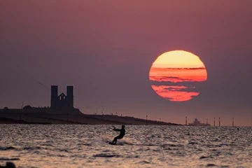 Minnis Bay, sun setting over Reculver Towers and wind surfer. 1